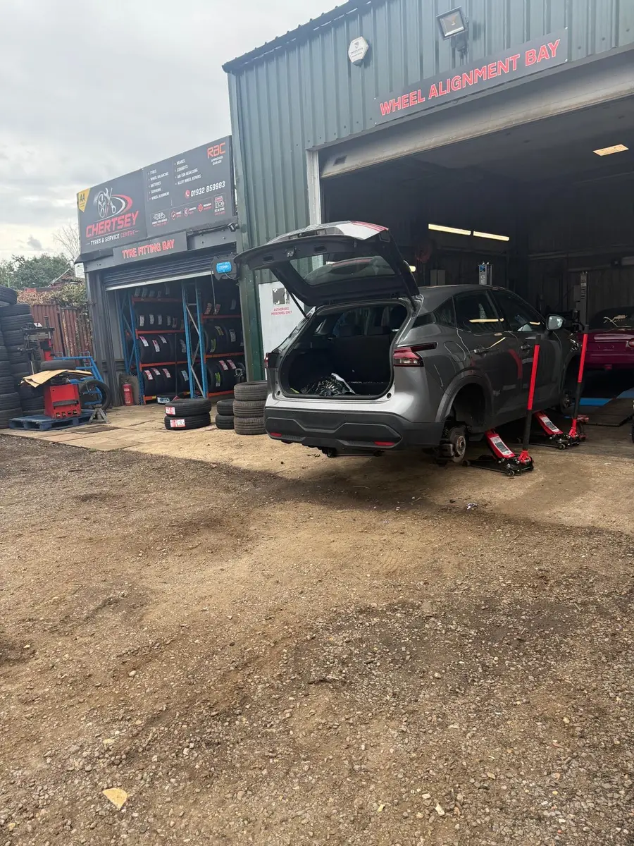 Chertsey Tyres & Service Centre workshop on Free Prae Road, Chertsey, with the wheel alignment bay open and a car being worked on
